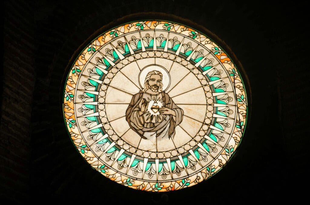 Circular stained glass window illustrating Jesus Christ, a serene religious artwork.