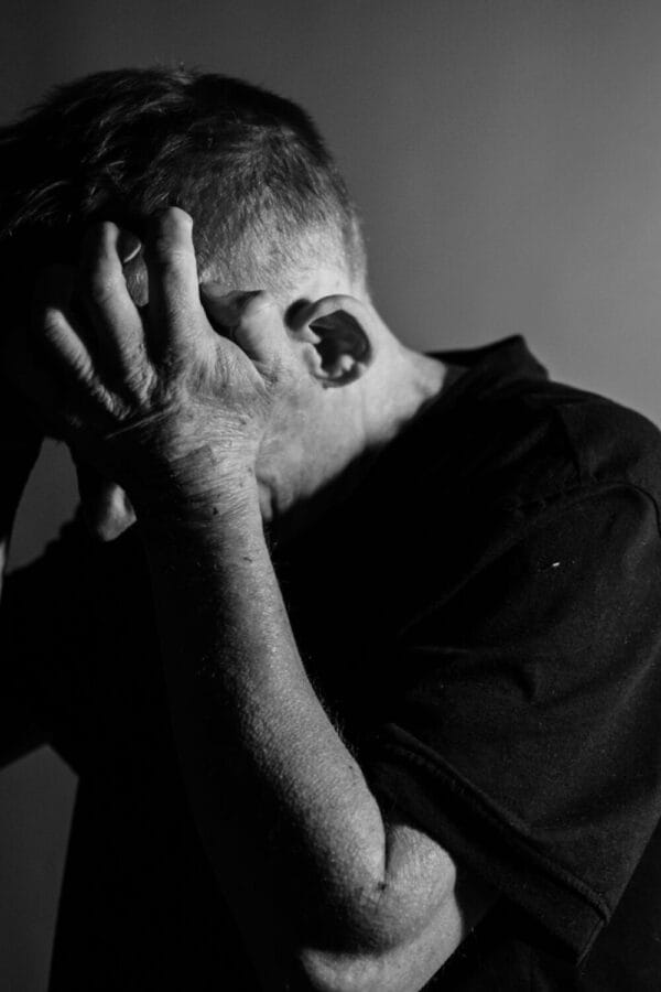 man clutching head in anger